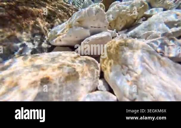 Natural river rock background with clear water ripple and stones ...