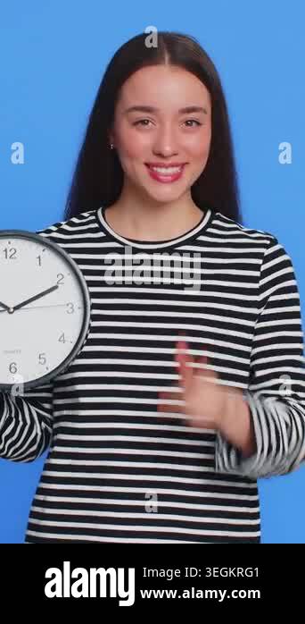 It is your time, hurry up. Caucasian woman showing time on wall office ...