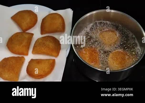 Portuguese rissois being fried in hot oil, a traditional appetizer ...