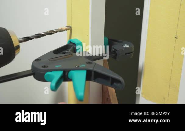 drill creates a hole in a cabinet door for installing a handle. High ...