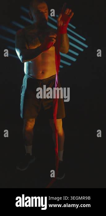 A man performs exercises using a red resistance band in an indoor gym ...