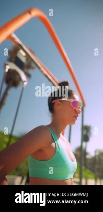 Beach workout woman performing lunges in teal sports bra and reflective ...