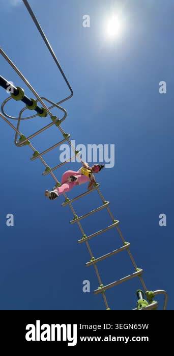 Female athlete climbing ladder under sun, focused grip and steady pace ...