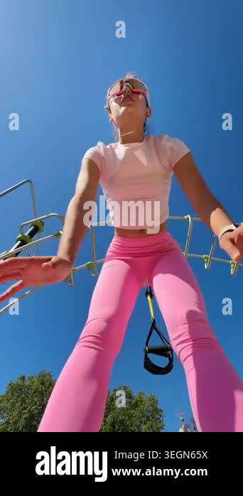 White woman trainer engaging camera while training with suspension ...