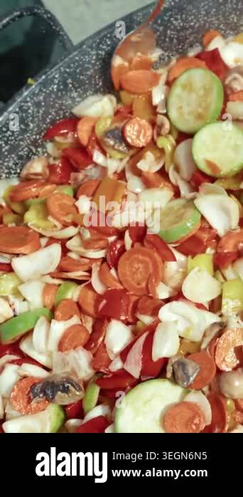 Chopped vegetables including carrots, bell peppers, and onions are ...