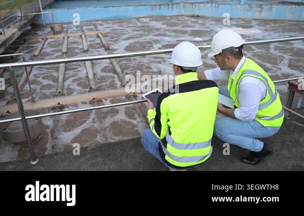 Water treatment plant engineers using digital tablet for inspection and ...
