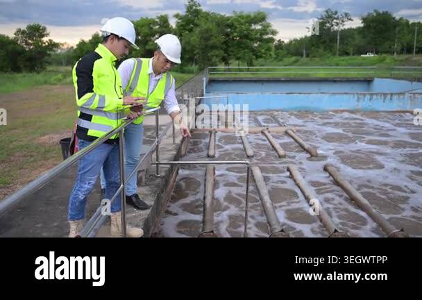 Water treatment plant engineers using digital tablet for inspection and ...