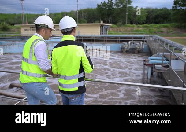 Water treatment plant engineers using digital tablet for inspection and ...