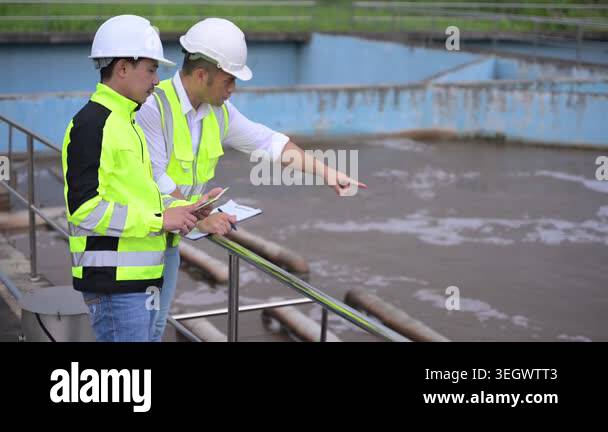 Water treatment plant engineers using digital tablet for inspection and ...