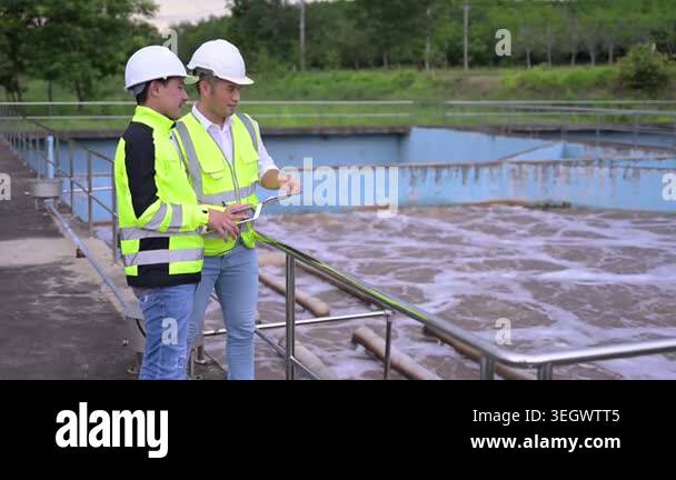 Water treatment plant engineers using digital tablet for inspection and ...