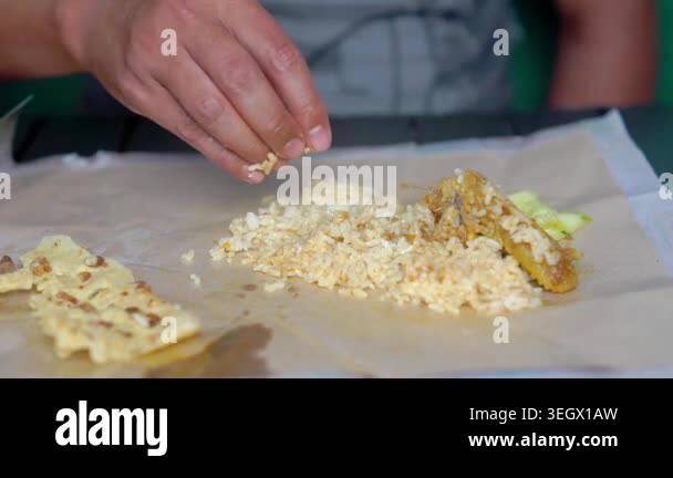 Indonesian eating rice and curry chicken with rempeyek (crackers with ...