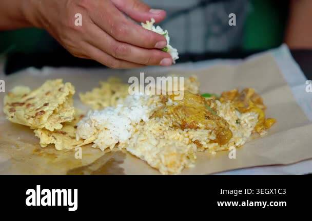 Indonesian eating rice and curry chicken with rempeyek (crackers with ...