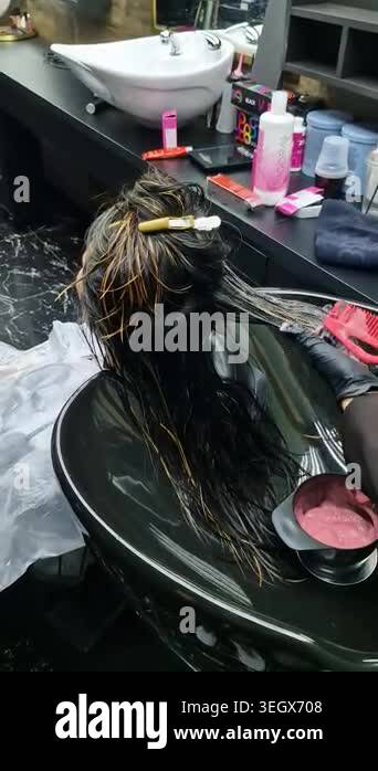 Close-up of hair lightening process. Hair strands placed on foil with ...