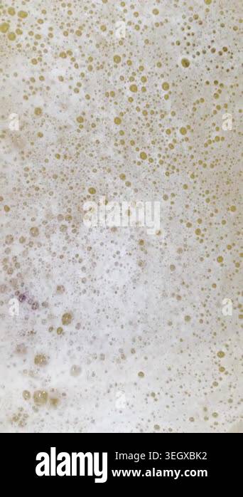 Vertical video shows swirling soapy bubbles from bubble bath creating ...