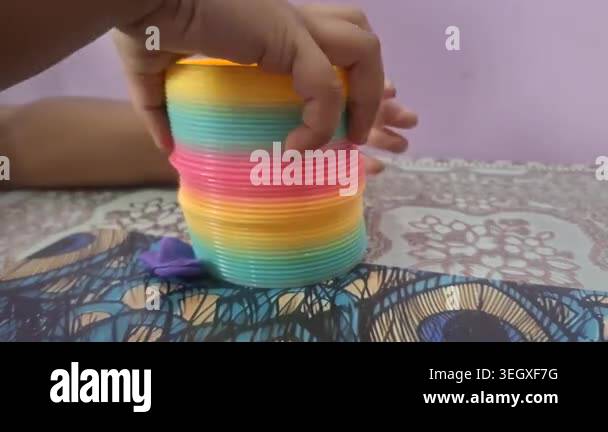 Colorful magic rainbow spring toy stretching dynamically with vibrant ...
