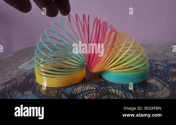 Colorful magic rainbow spring toy stretching dynamically with vibrant ...