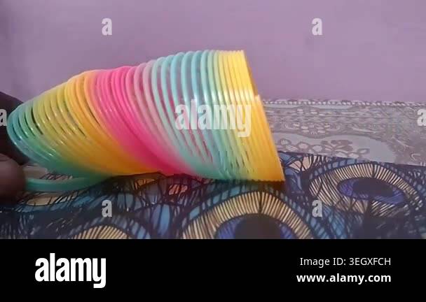 Colorful magic rainbow spring toy stretching dynamically with vibrant ...