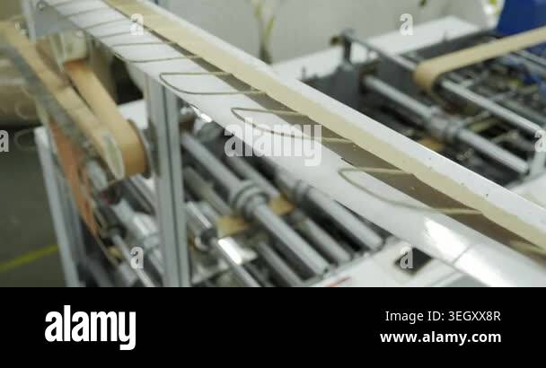 Industrial conveyor where paper bags are made, factory equipment with ...