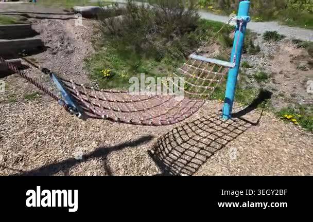 Modern playground equipment with net swing and wooden elements in ...