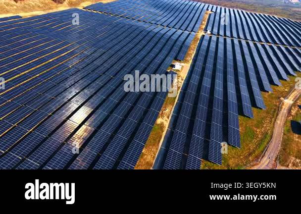 Aerial solar panel rows across utility power plant. Drone view of dense ...