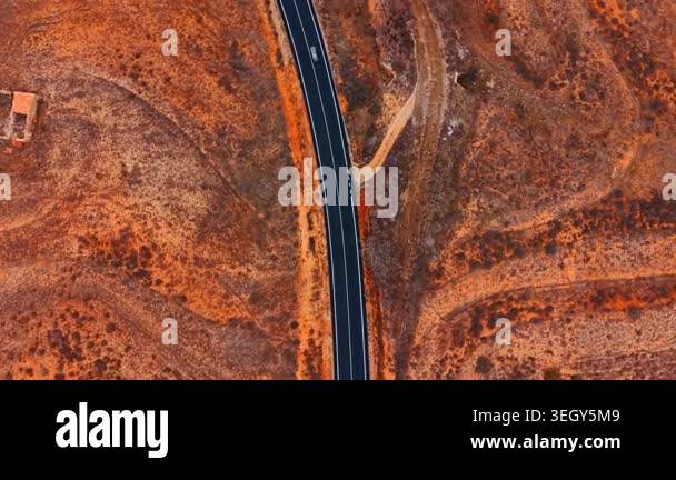 Vertical drone view of asphalt road and stream. Vertical drone view of ...