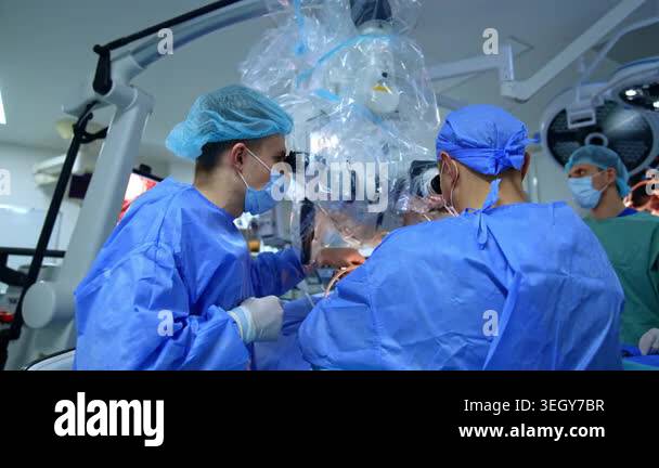 Male doctors in blue uniforms stand at the modern microscope. Medics ...