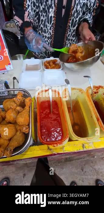 4k point-of-view video of a food vendor's hands seasoning a customer's ...