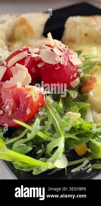 Fresh cherry tomato and arugula salad with almond flakes served with ...