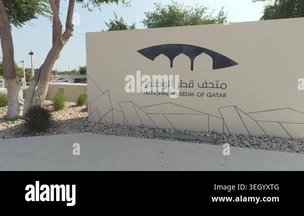 Sign of the National Museum of Qatar in a landscaped outdoor area under ...
