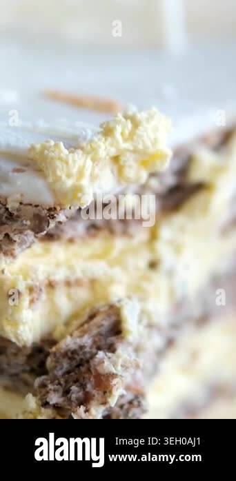 A slice of cake with smooth white cream and white chocolate sits on a ...