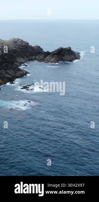 Aerial Coastal Cliff Overlooking Churning Sea, Orange Rock Faces ...
