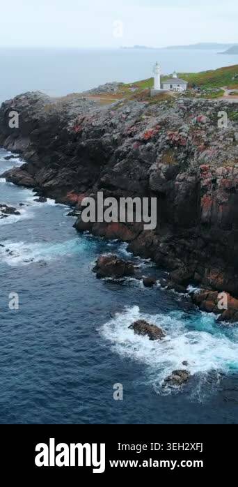 Aerial Coastal Cliff Overlooking Churning Sea, Orange Rock Faces ...