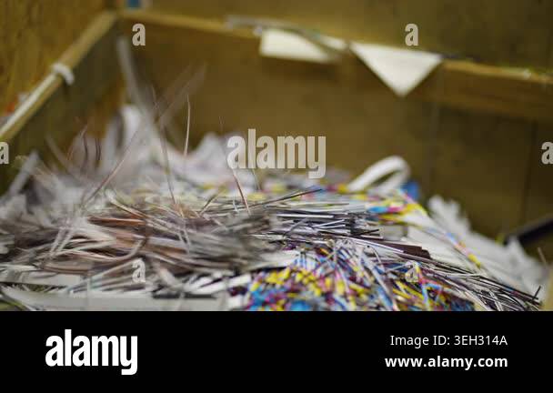Closeup of a paper shredder machine cutting strips of printed sheets ...