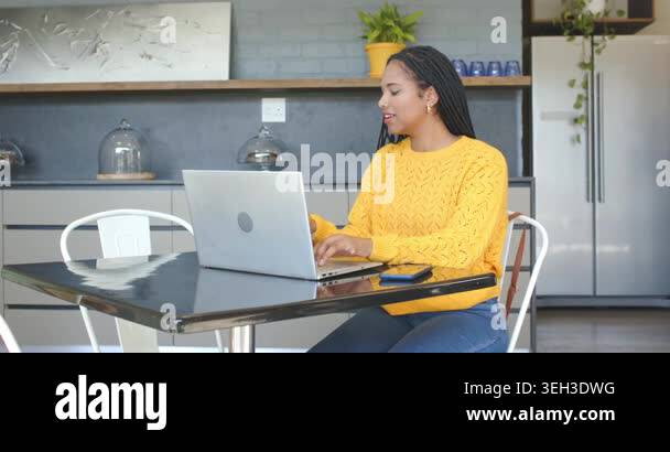 Image showcasing Woman working on laptop, checking smartphone, sipping from red mug in ...