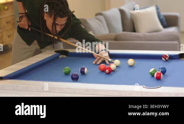 After cue tip aligning behind rack, pool player drawing back, breaking ...