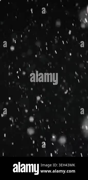 Vertical view of heavy snow falling on a black background. Real ...