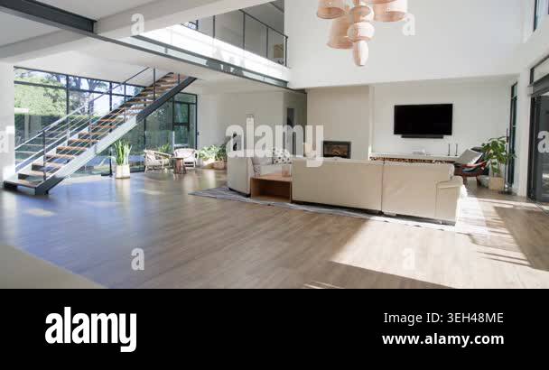 Sunlight is moving through windows lighting beige sofa and rug in ...