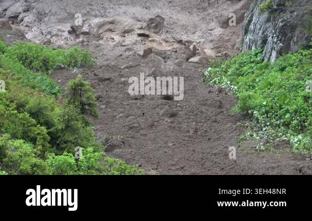 Ground Slide Move Clay landslide moves down valley slope after heavy rain with raw earth ...