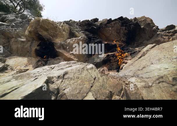 Burning methane flame emerges from rock crack as natural gas leaks from ...