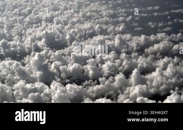 Small cotton clouds seen from plane window in bright sky during an ...