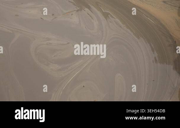 Muddy water swirls with thick sediment in a close industrial view of ...