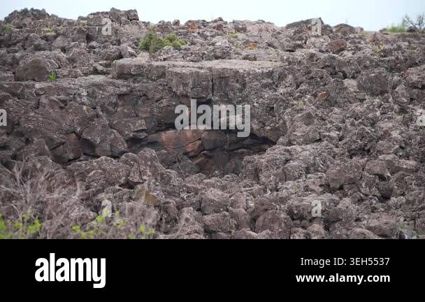 Volcanic cave ceiling displays porous gas textures and layered stone ...