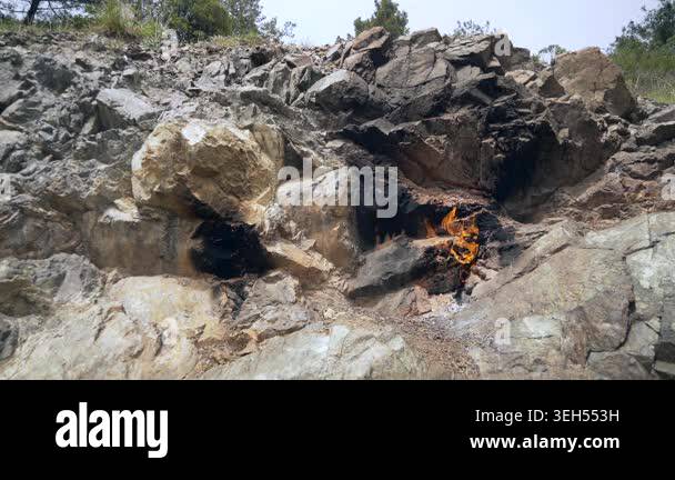 Burning methane flame emerges from rock crack as natural gas leaks from ...