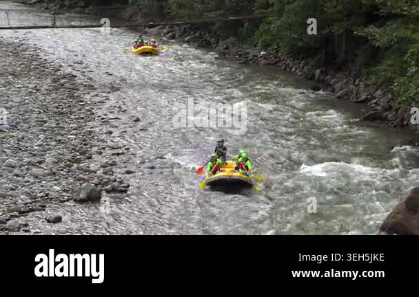 Yellow inflatable rafts descend fast river, whitewater adventure ...