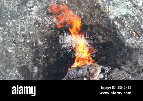 Methane flames burst from rocky ground cracks, natural gas fire burning ...