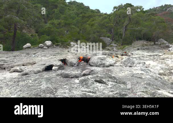 Methane flames burst from rocky ground cracks, natural gas fire burning ...