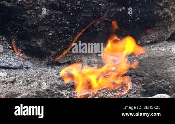 Methane flames burst from rocky ground cracks, natural gas fire burning ...