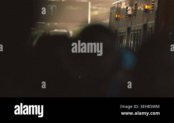 A train moves slowly through a dark area. Bright city lights appear in ...
