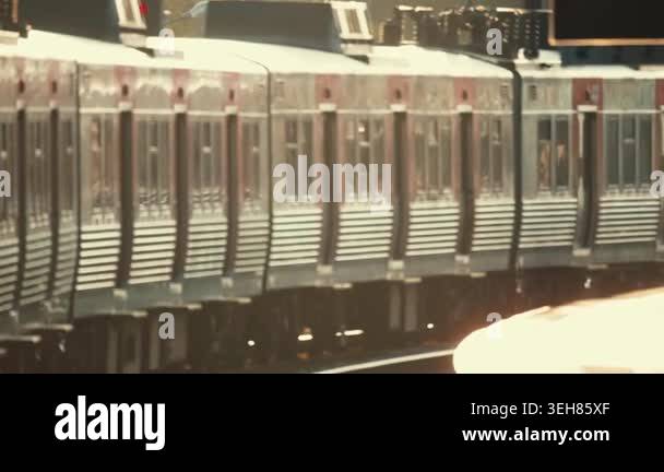 Trains enter and leave the station as passengers wait on the platform ...