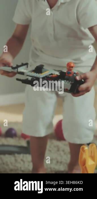 caucasian toddler assembling colorful train set on carpet, small hands ...